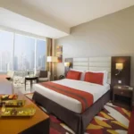 نمای کلی از اتاق Standard King Room در هتل میلنیوم سنترال داون تاون دبی با تخت کینگ و چشم‌انداز شهر.